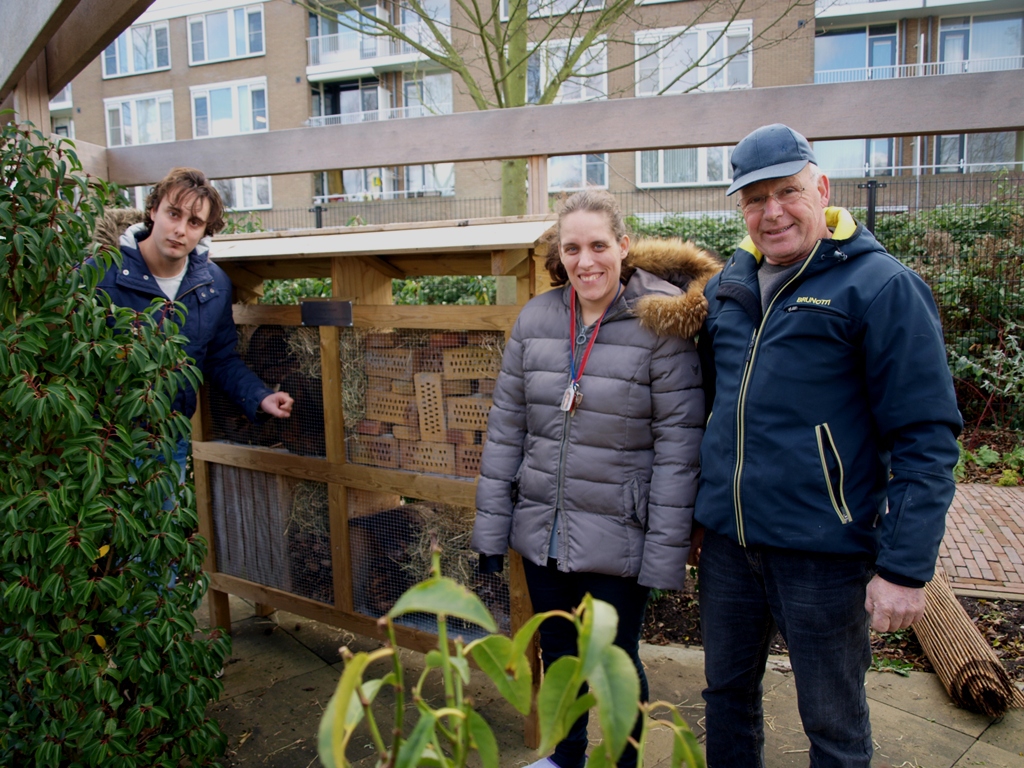 Otto Seijn legt bewoners Julian en Denise alles uit over het insectenhotel. Foto | pr